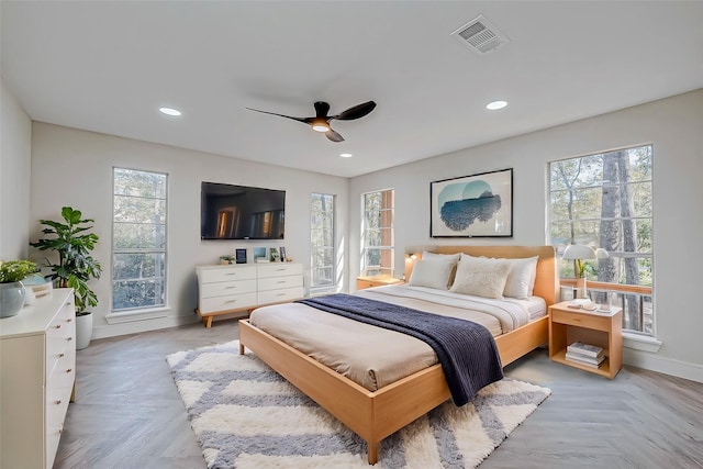 bedroom with multiple windows, light parquet floors, and ceiling fan