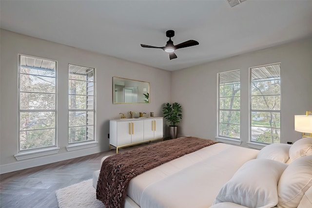 bedroom featuring multiple windows, ceiling fan, and parquet flooring