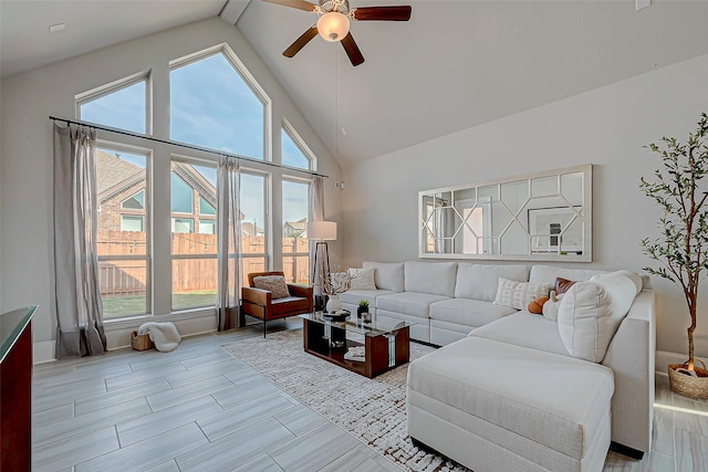 living room with light hardwood / wood-style floors, high vaulted ceiling, and ceiling fan