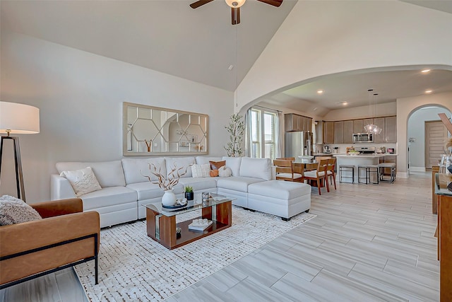 living room featuring ceiling fan, light wood-type flooring, and high vaulted ceiling