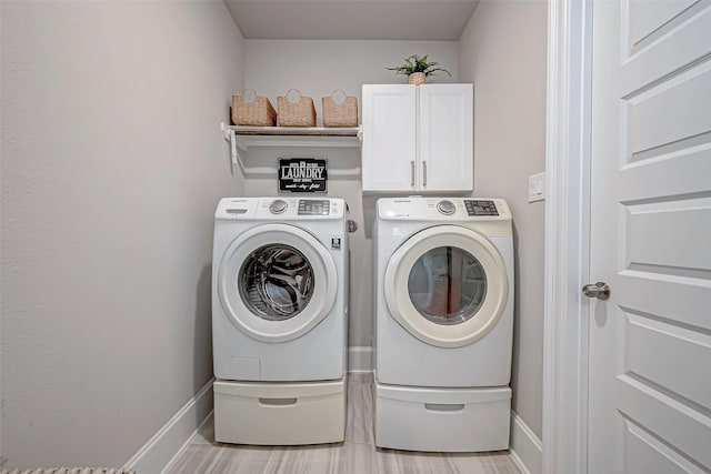 clothes washing area featuring cabinets and independent washer and dryer