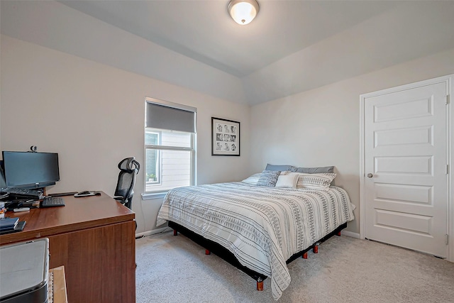 bedroom featuring light colored carpet and vaulted ceiling