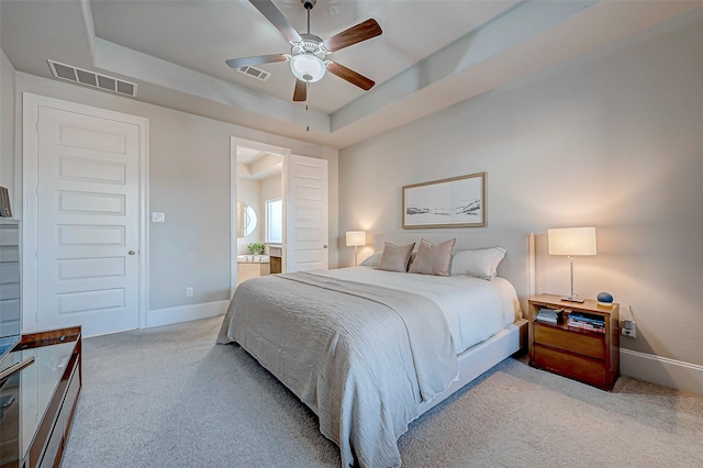 bedroom with ceiling fan, a raised ceiling, and light carpet