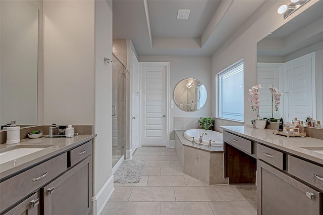 bathroom featuring a raised ceiling, plus walk in shower, tile patterned flooring, and vanity