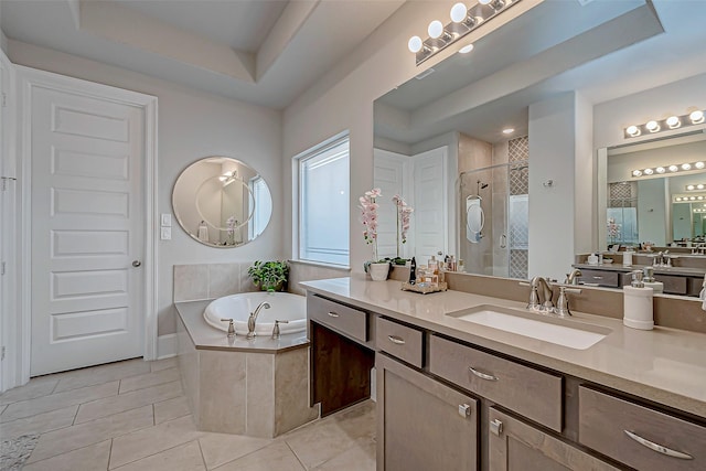 bathroom with separate shower and tub, vanity, tile patterned flooring, and a tray ceiling