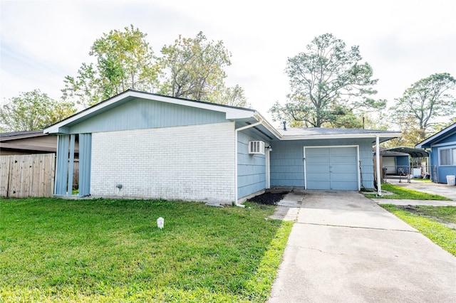 view of front of home featuring a wall unit AC, a front lawn, a carport, and a garage