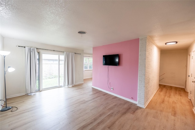 spare room with light hardwood / wood-style flooring and a textured ceiling