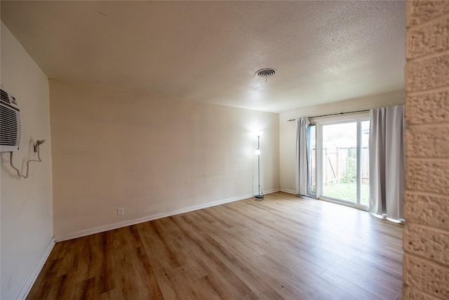 spare room with a textured ceiling and light hardwood / wood-style flooring