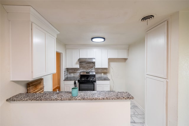 kitchen with tasteful backsplash, light stone counters, white cabinets, and stainless steel gas range