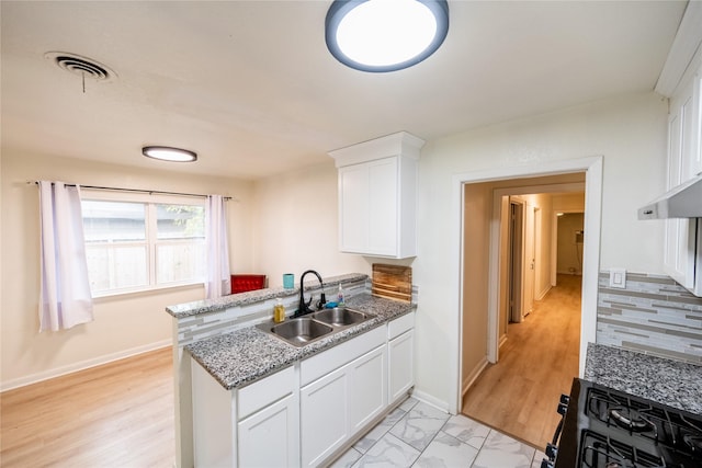 kitchen with white cabinetry, sink, light stone counters, black range with gas cooktop, and light hardwood / wood-style floors