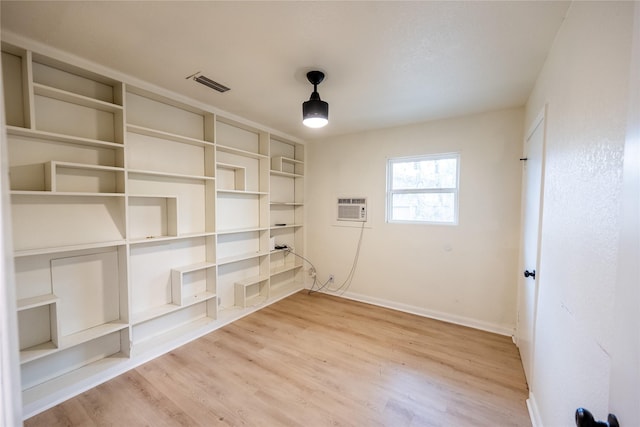 interior space with hardwood / wood-style floors and a wall unit AC