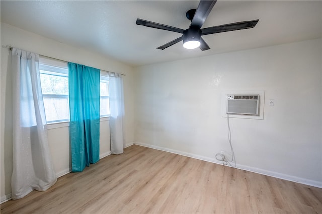 spare room featuring a wall mounted AC, ceiling fan, and light hardwood / wood-style flooring