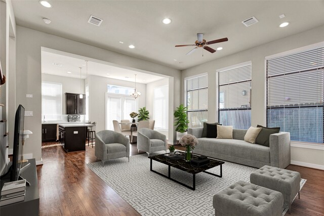 living room with hardwood / wood-style floors, ceiling fan with notable chandelier, and a healthy amount of sunlight