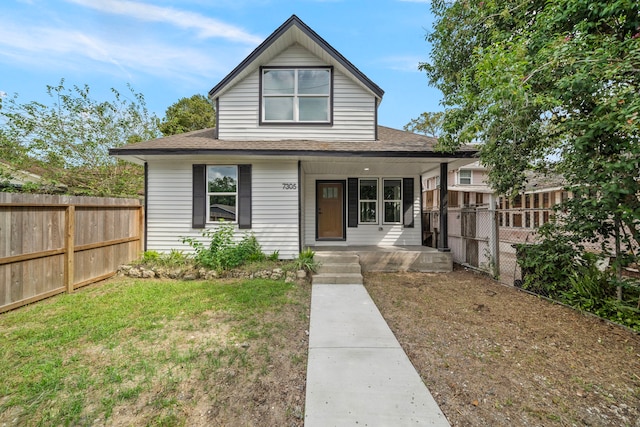 bungalow featuring a porch and a front lawn