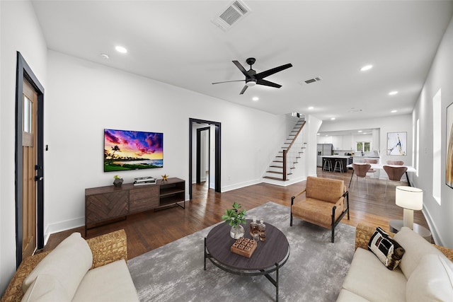 living room with ceiling fan and dark wood-type flooring