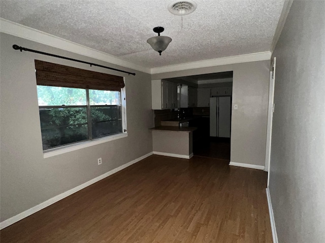 unfurnished living room with crown molding, dark hardwood / wood-style flooring, and a textured ceiling