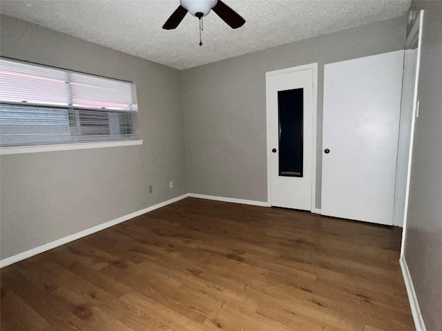 unfurnished room featuring ceiling fan, hardwood / wood-style floors, and a textured ceiling