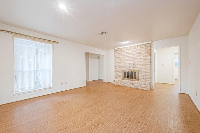 unfurnished living room with a fireplace and light hardwood / wood-style floors