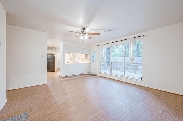 unfurnished living room with ceiling fan and light hardwood / wood-style flooring