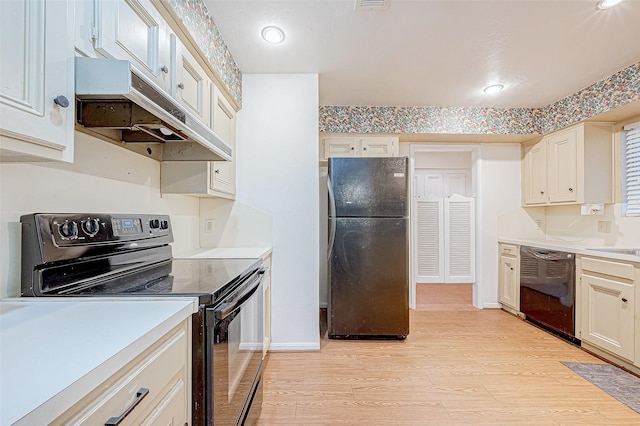 kitchen featuring sink, light hardwood / wood-style floors, and black appliances