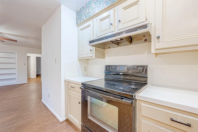 kitchen with ceiling fan, black electric range oven, and light hardwood / wood-style floors