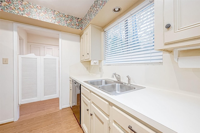 kitchen featuring dishwasher, sink, and light wood-type flooring