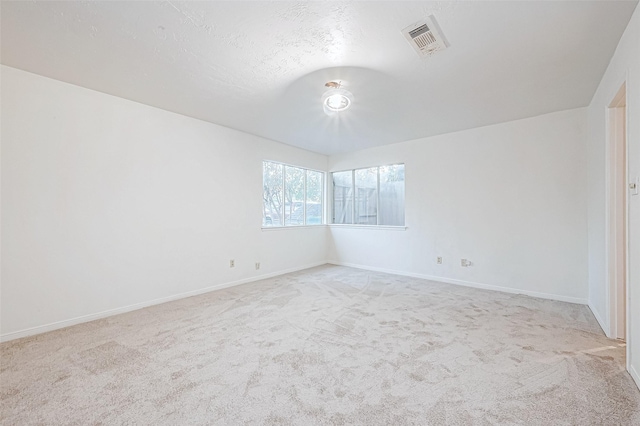 carpeted empty room with a textured ceiling