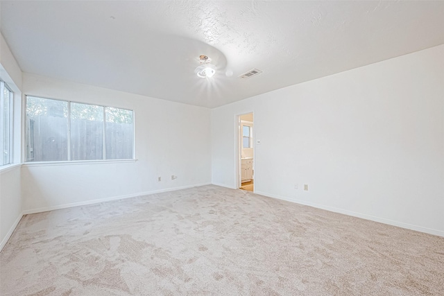 carpeted empty room featuring a textured ceiling