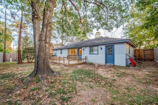 rear view of property featuring a wooden deck