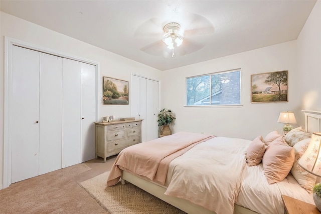 carpeted bedroom featuring ceiling fan and two closets