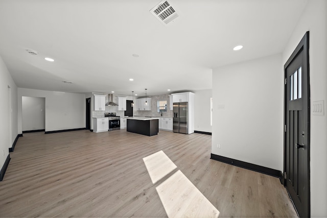 unfurnished living room with sink and light hardwood / wood-style floors