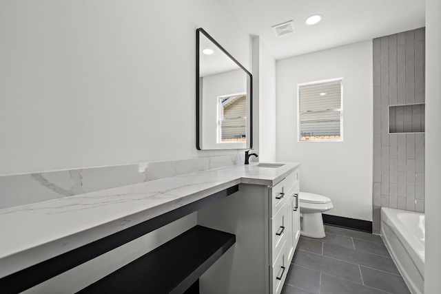 full bathroom featuring tile patterned flooring, vanity, tiled shower / bath combo, and toilet