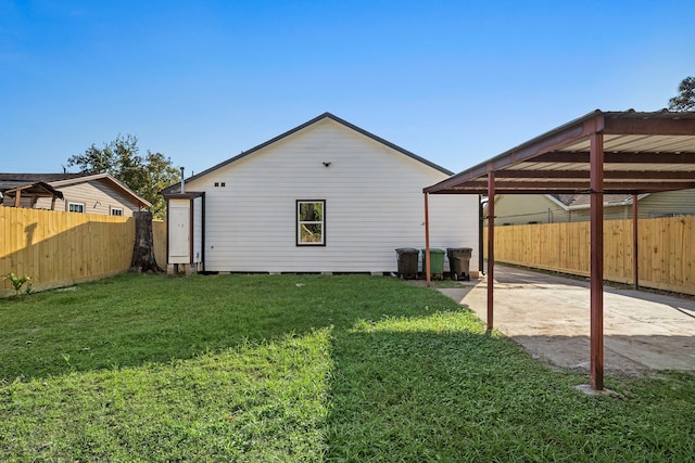 rear view of house featuring a lawn and a carport