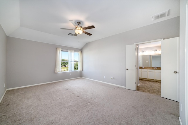 unfurnished bedroom featuring connected bathroom, ceiling fan, sink, light colored carpet, and lofted ceiling