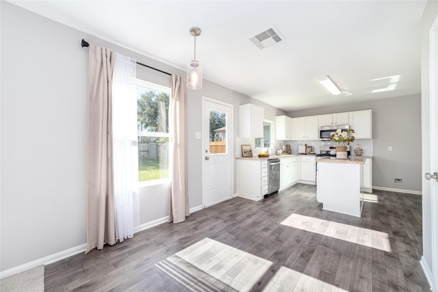 kitchen with white cabinetry, hanging light fixtures, dark hardwood / wood-style flooring, a kitchen island, and appliances with stainless steel finishes