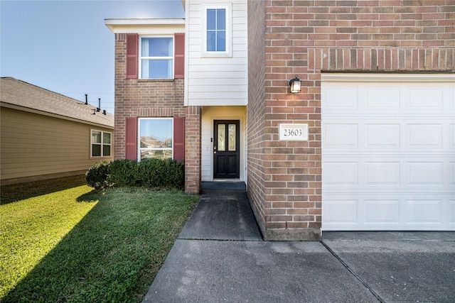 view of exterior entry featuring a yard and a garage