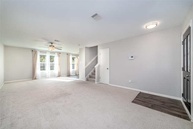 unfurnished living room with ceiling fan and carpet