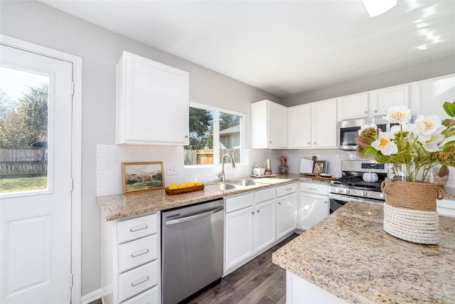 kitchen with white cabinets, sink, light stone counters, dark hardwood / wood-style flooring, and stainless steel appliances