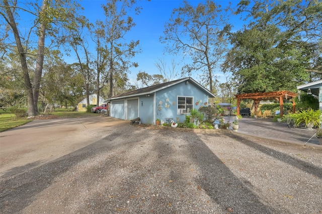 view of property exterior with a pergola and a garage