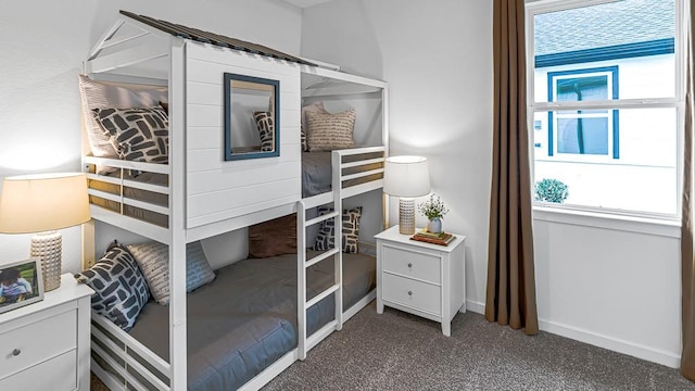 bedroom featuring dark colored carpet and baseboards