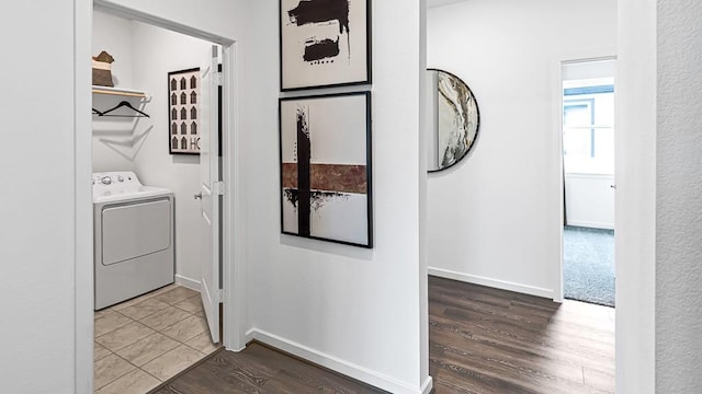 clothes washing area featuring wood finished floors, washer / clothes dryer, baseboards, and laundry area