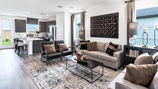 living room featuring light wood finished floors, visible vents, and recessed lighting