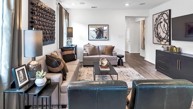 living room with baseboards, visible vents, wood finished floors, and recessed lighting