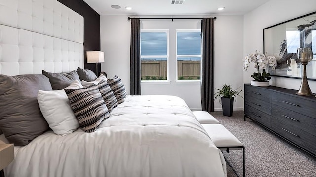 bedroom with carpet floors, multiple windows, visible vents, and baseboards