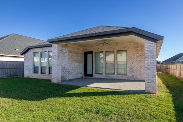 rear view of property with a lawn, ceiling fan, and a patio