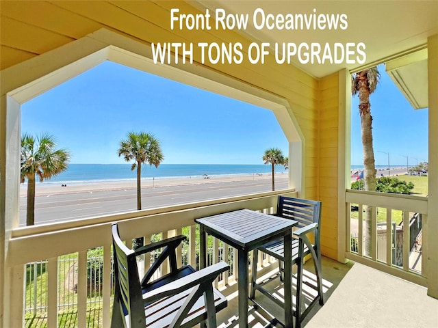 balcony featuring a water view and a beach view