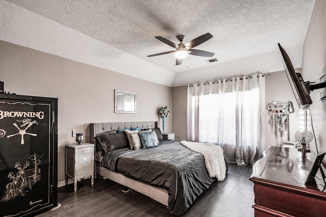 bedroom with a textured ceiling, dark hardwood / wood-style flooring, and ceiling fan