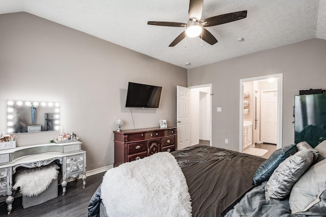 bedroom with ceiling fan, ensuite bath, dark wood-type flooring, and vaulted ceiling