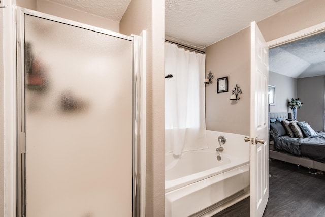 bathroom featuring separate shower and tub, hardwood / wood-style floors, a textured ceiling, and lofted ceiling