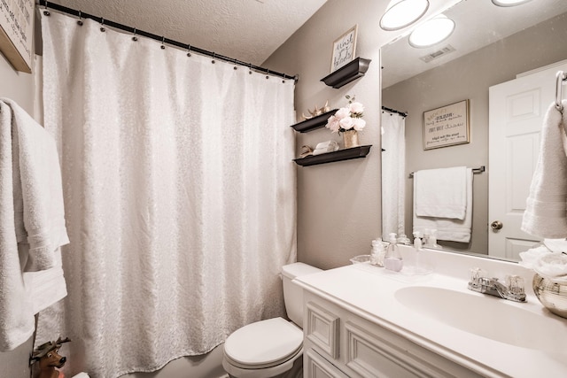 bathroom featuring vanity, a shower with curtain, a textured ceiling, and toilet